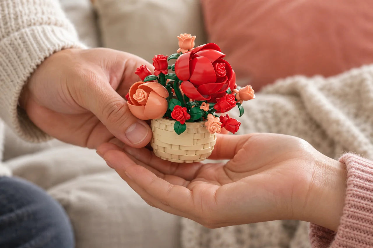 A tiny Sweet Roses bouquet being passed between two adult hands.