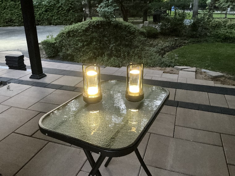 Customer photo: two gold lanterns on a patio table.