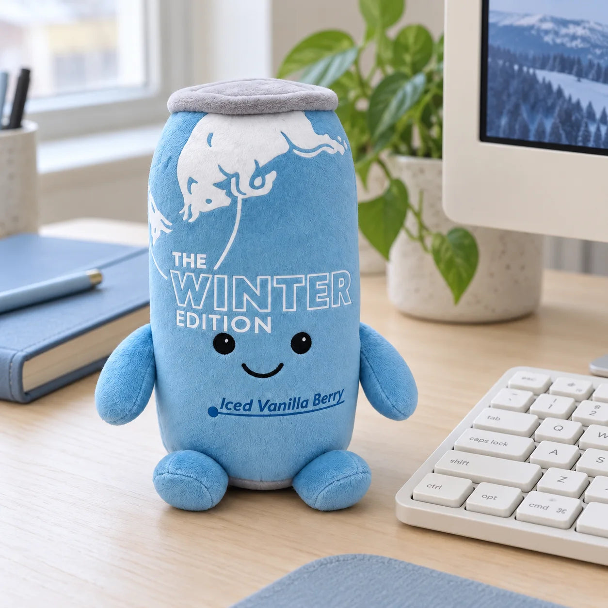 Winter Blue plush beside a keyboard on a light wooden desk.