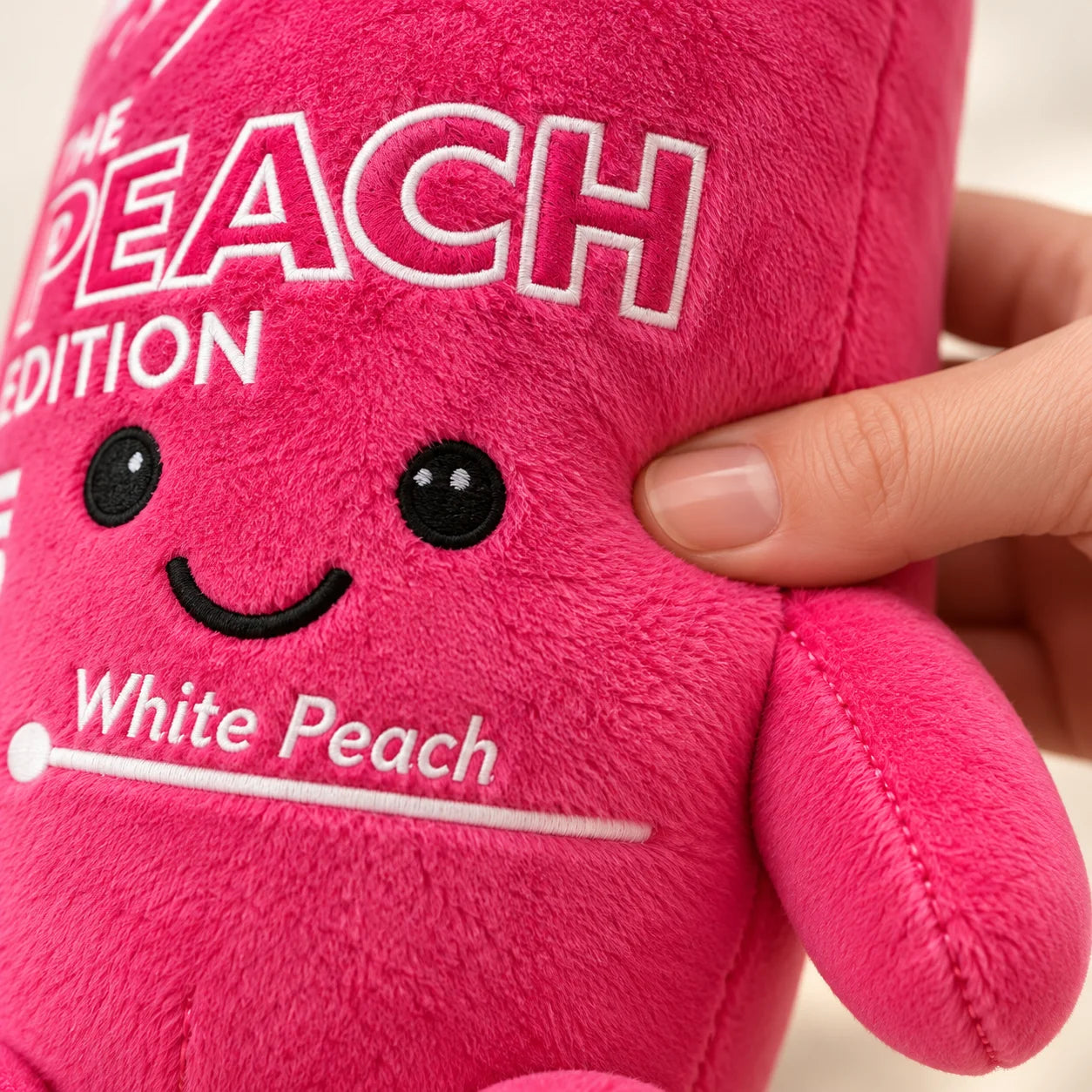 Close-up of the soft pink plush fabric, little smile and stitched arm.