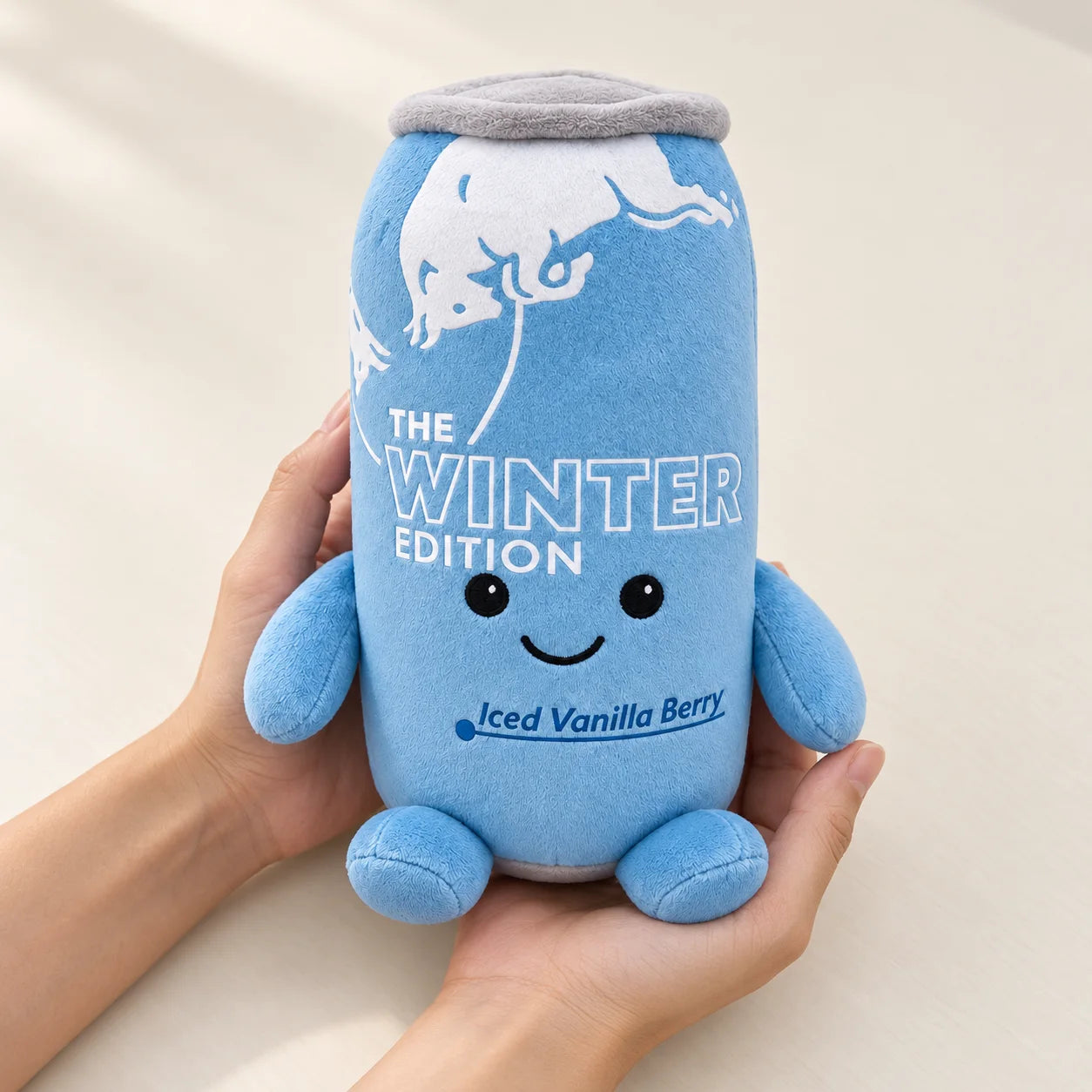 A 22 cm Winter Blue plush held in adult hands for a sense of scale.