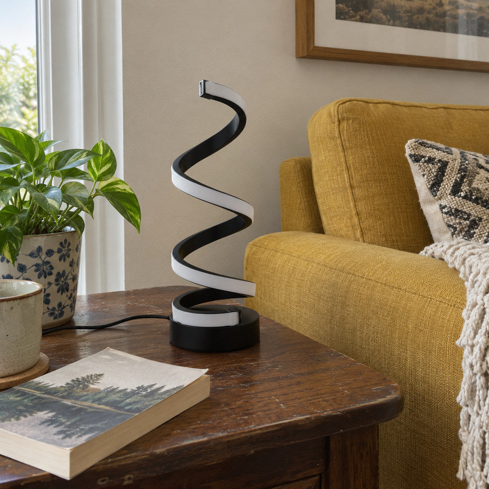 BLACK spiral lamp switched OFF on a slightly worn walnut side table beside a mustard fabric sofa.