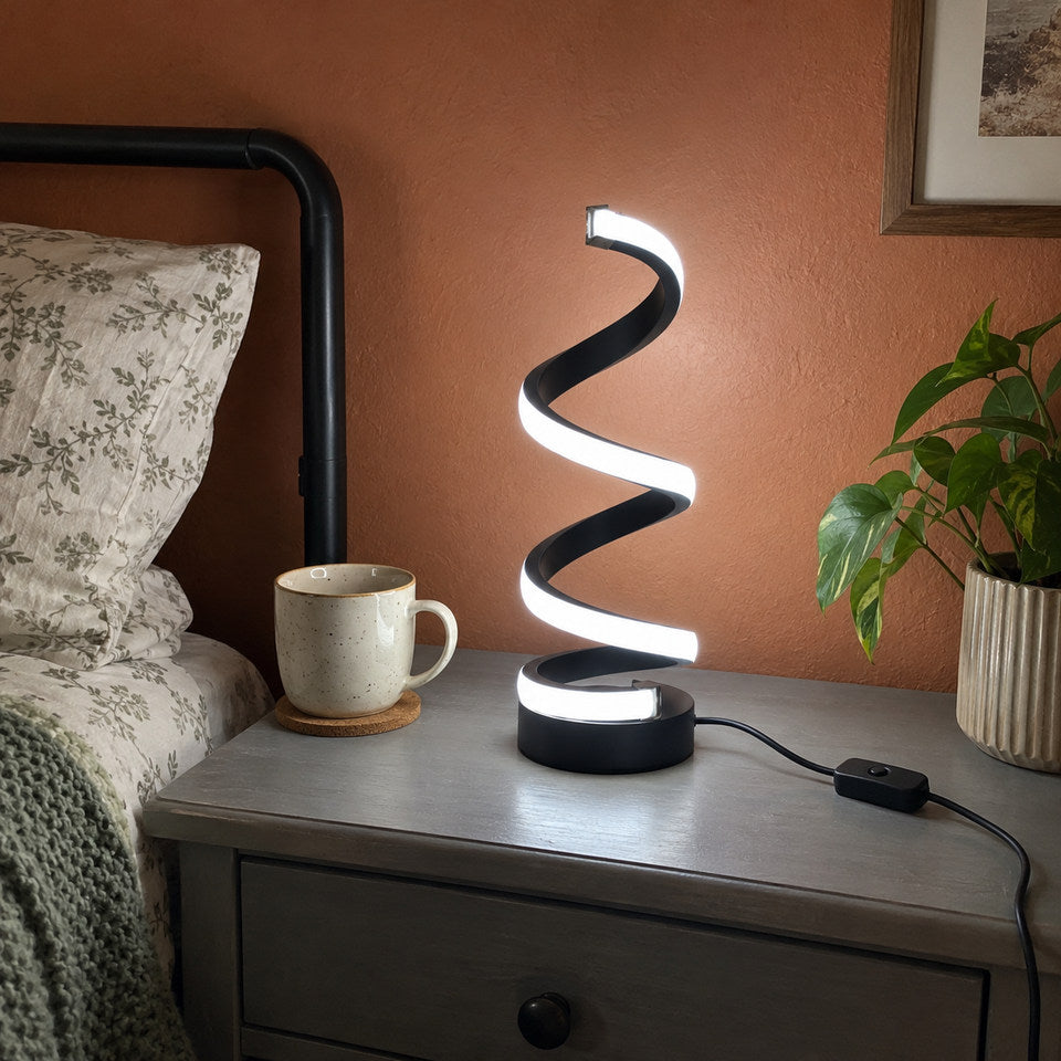 BLACK spiral lamp on a small grey bedside chest, terracotta wall and ordinary home textures, mild downward handheld phone angle.
