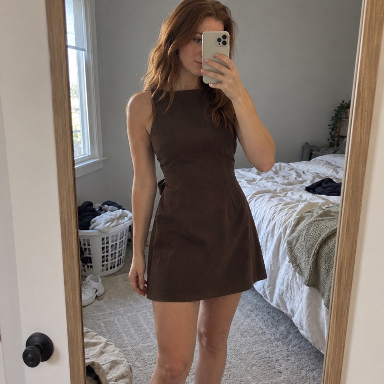brown mini dress in a bedroom mirror selfie.