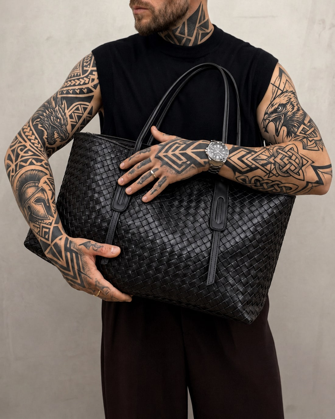 Black woven tote carried by its shoulder handles