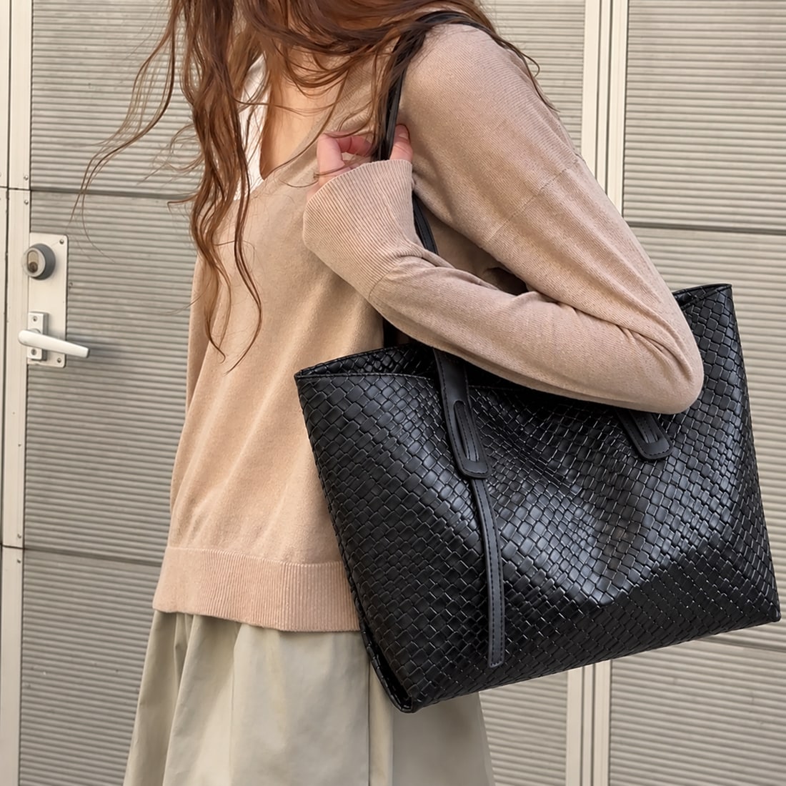Black woven tote carried with an everyday outfit