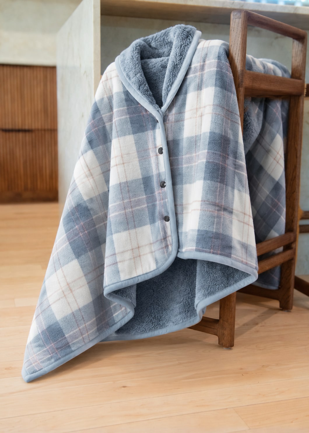 Blue Plaid blanket wrap showing its three black front buttons and fleece lining