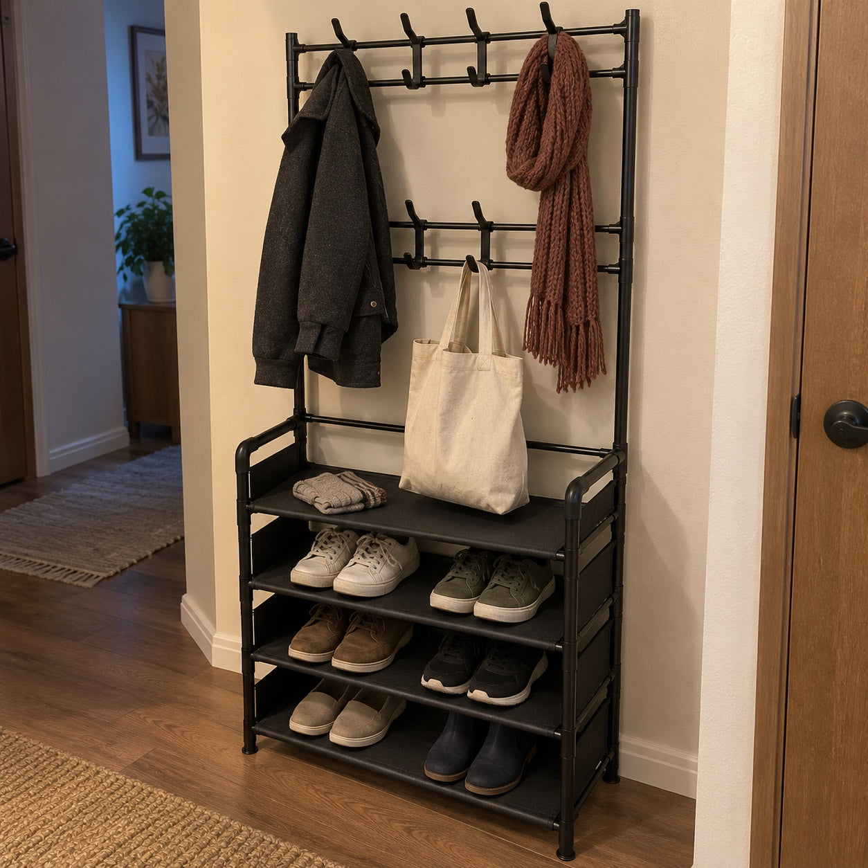 the black rack in a warm cream hallway, holding a charcoal jacket, knitted burgundy scarf, canvas tote, folded gloves and casual shoes.