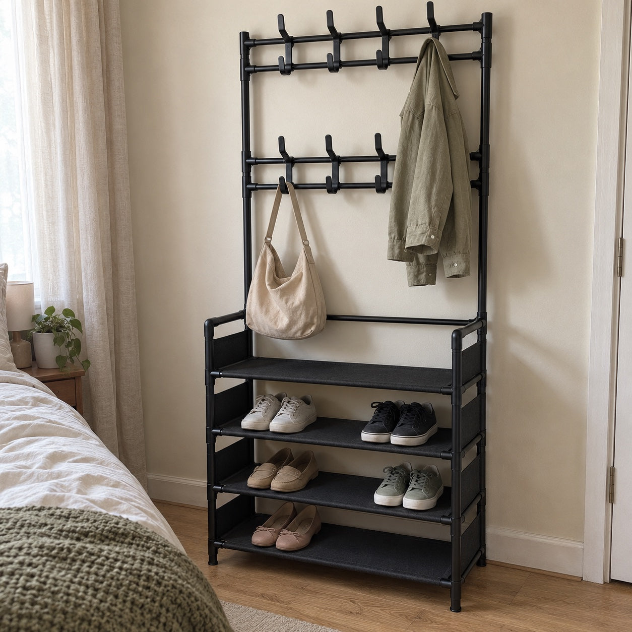 the black rack beside a bedroom bed, with an olive overshirt, beige shoulder bag, flats and sneakers.