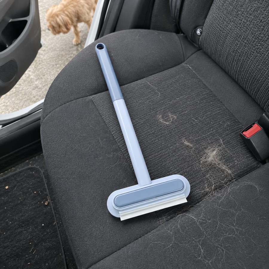 Blue brush on the fabric seat of a parked car.