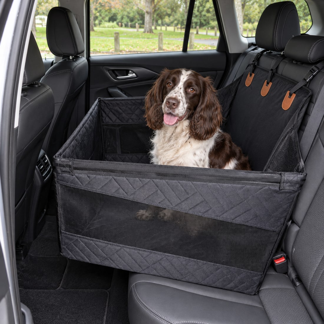 Black hard-base pet travel seat with a spaniel in a parked vehicle.
