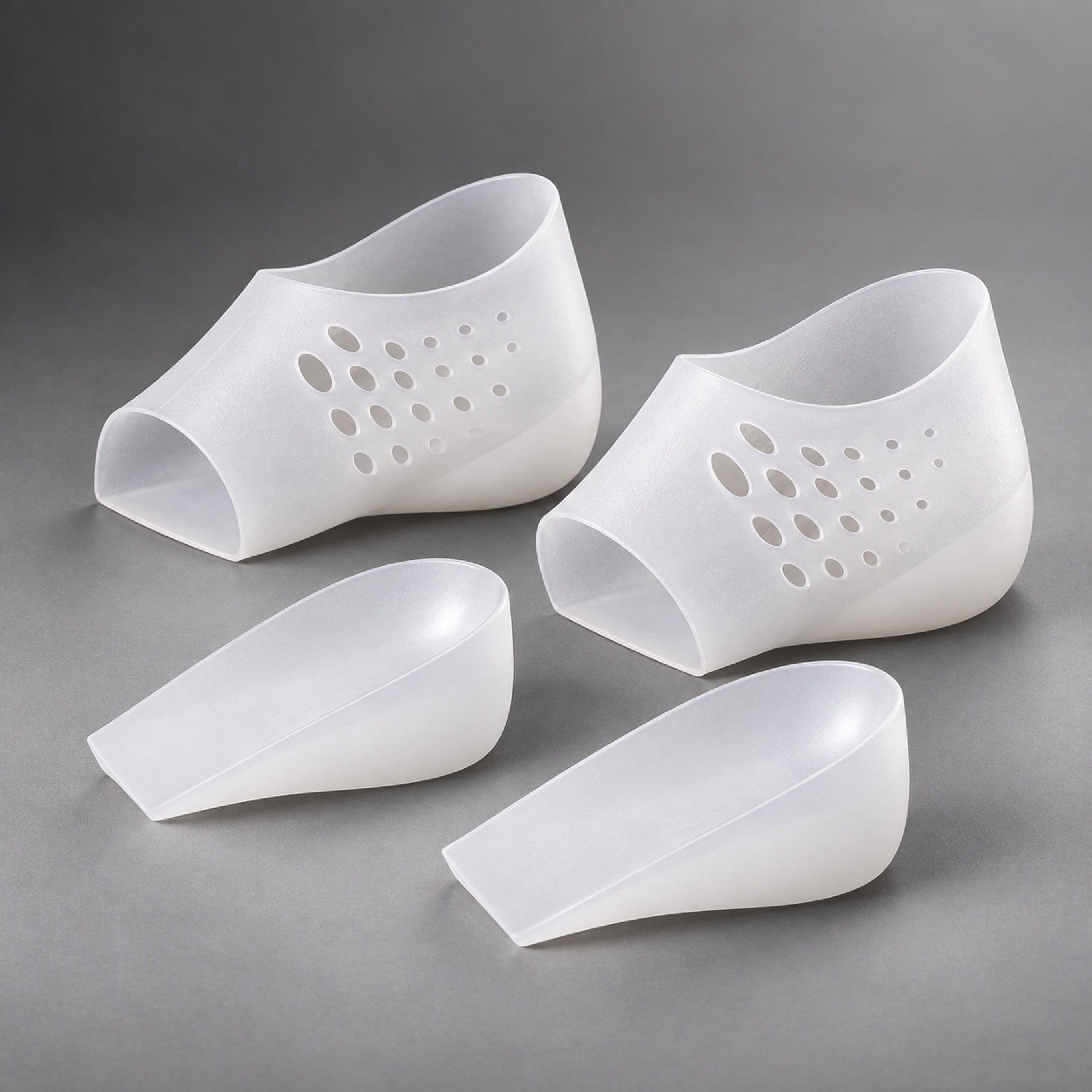 A pair of translucent silicone heel sleeves with lift inserts