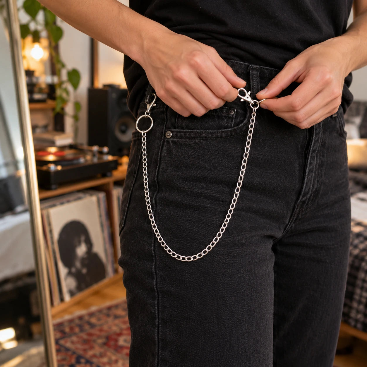 Hands fastening A single chain to a denim belt loop