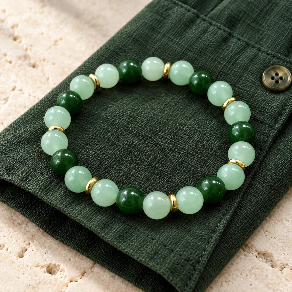 Single green bracelet resting on a deep green linen shirt cuff.