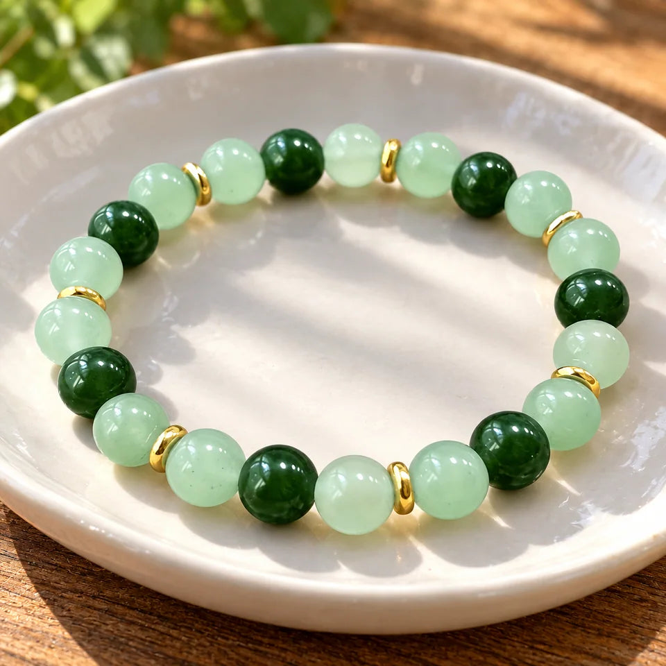 Single green bracelet in a shallow white ceramic dish in afternoon light.