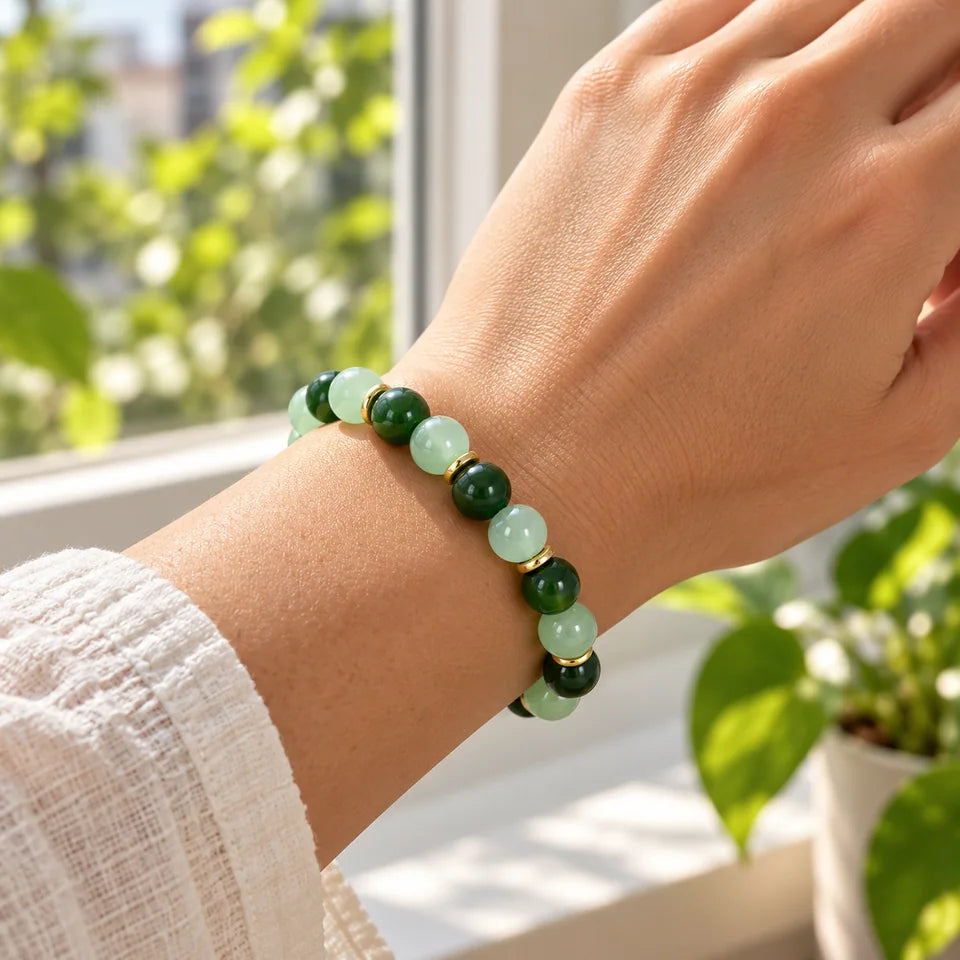 One green bracelet on an adult wrist near a sunlit apartment window.