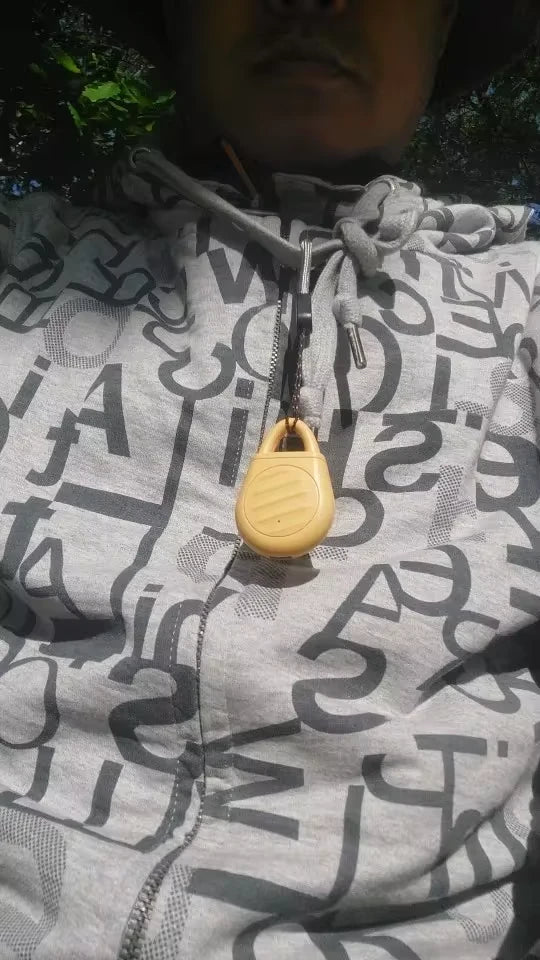 Customer photo of a yellow Pocket Outdoors device hanging from a cord on clothing.