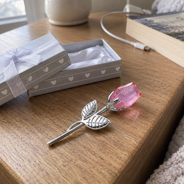 Blush and silver rose on an oak nightstand.