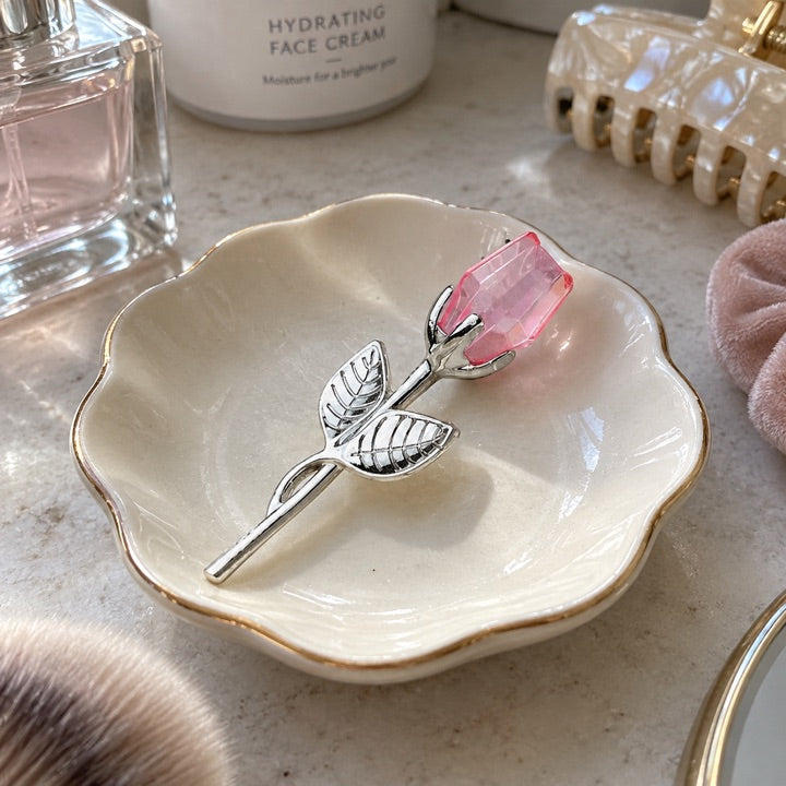 Blush and silver rose on a ceramic dressing-table dish.