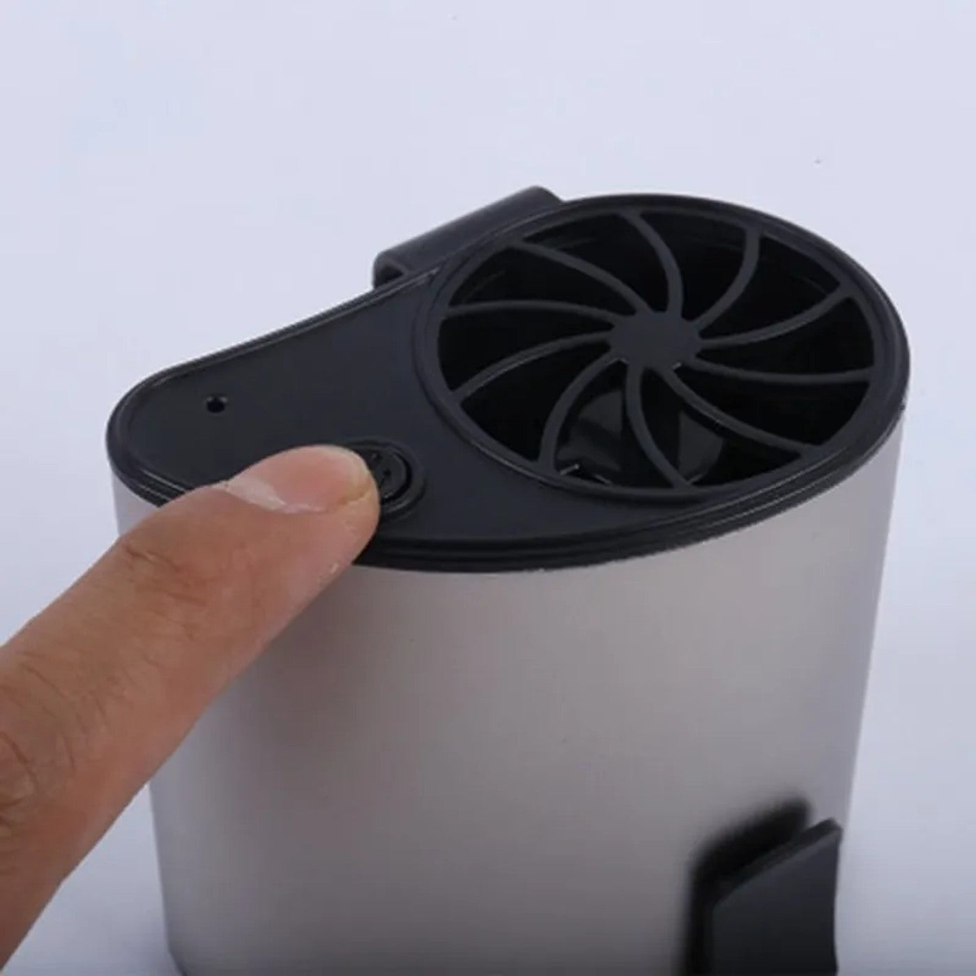 Finger pressing the round power control on the waist fan