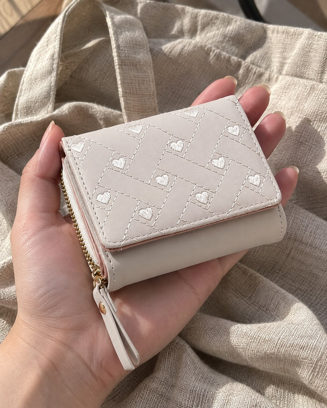 Photo of an ivory wallet over a linen tote